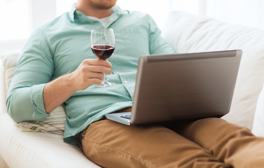 close up of man with laptop and wine glass
