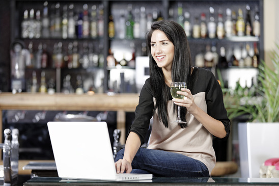 Woman on laptop in wine bar